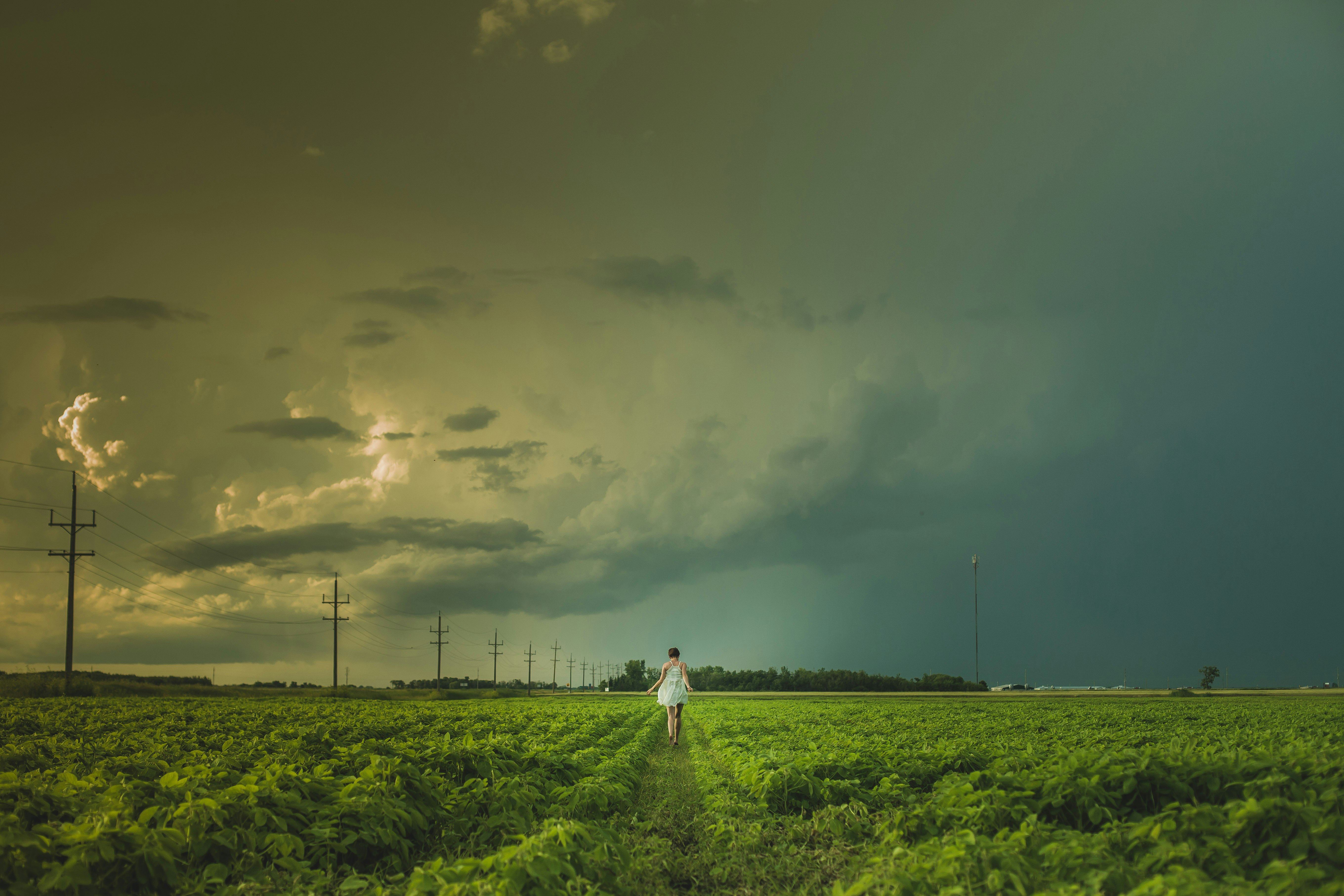 person walking near electric post under cloudy sky